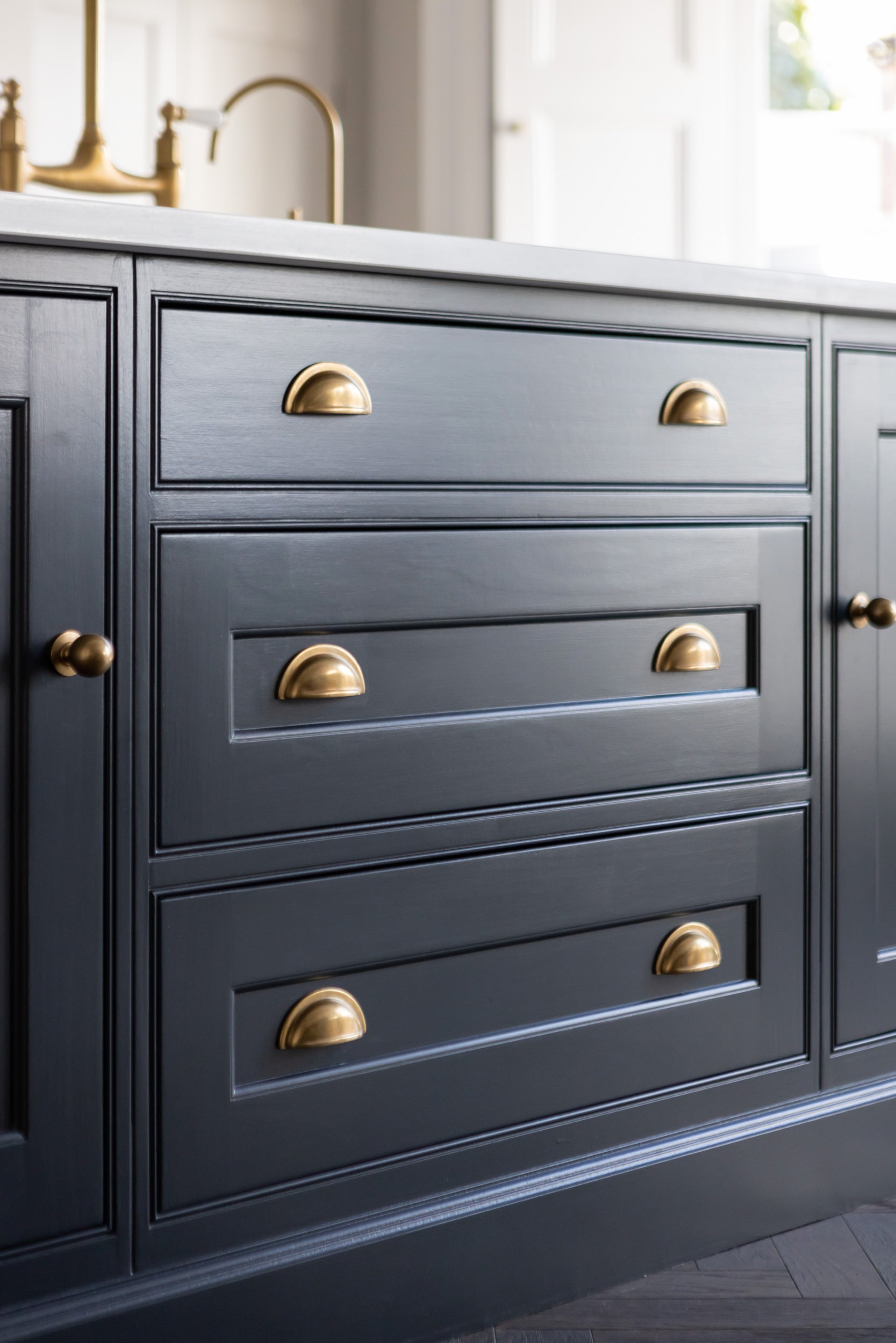Gray kitchen pantry cabinets accented with brushed brass hardware